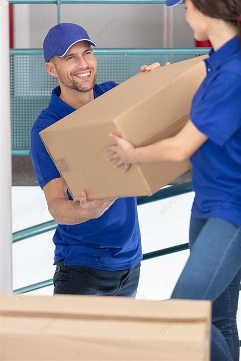 Dois Jovens Motoristas De Uniforme Azul Carregando Caixas De Papel O