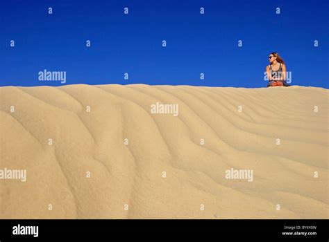 A tourist in the dunes of the Grand Erg Oriental (Sahara Desert) near ...