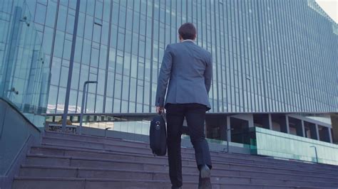 Businessman With Briefcase Walking Towards Building A Businessman In A