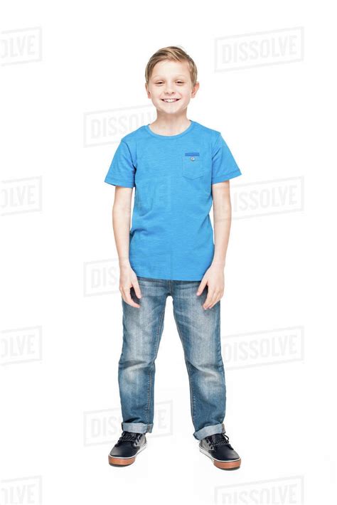 Full length view of cute little boy in jeans and blue t-shirt smiling at camera isolated on ...