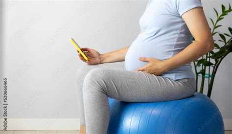 Pregnant Woman Feel Contractions Sitting On Fitball And Use Mobile Time