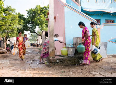 Indian Women Filling Plastic Pots With Water From A Standpipe In A