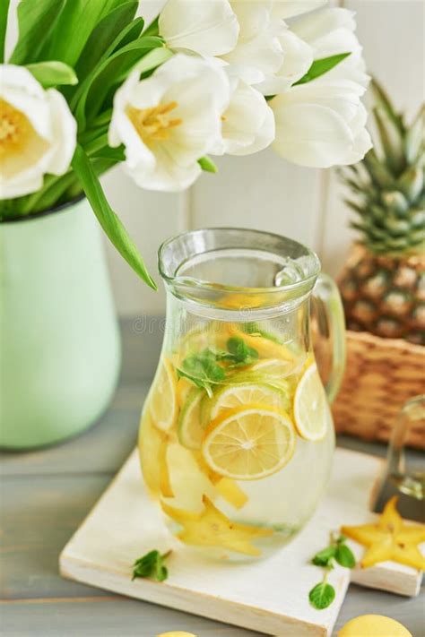 Tulipanes De Flores En La Mesa Frasco De Vidrio De Limonada Con Limones