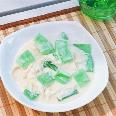 A White Bowl Filled With Food On Top Of A Bamboo Mat Next To A Green Drink