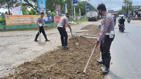 Personel Satlantas Polres Aceh Utara Tambal Jalan Rusak Digerus Banjir