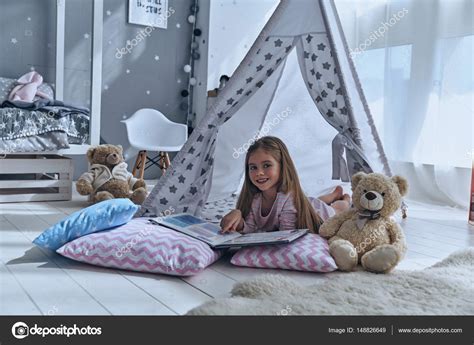 Lovely little girl reading book Stock Photo by ©gstockstudio 148826649