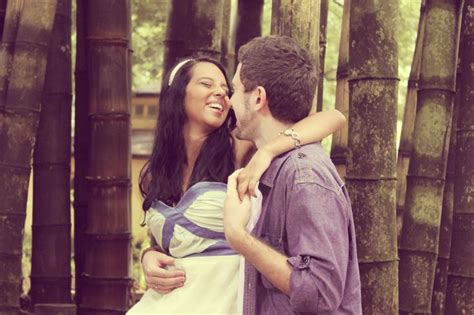 A Man And Woman Standing Next To Each Other In Front Of Bamboo Trees