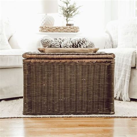 A Wicker Box Sitting On Top Of A Wooden Floor Next To A White Couch