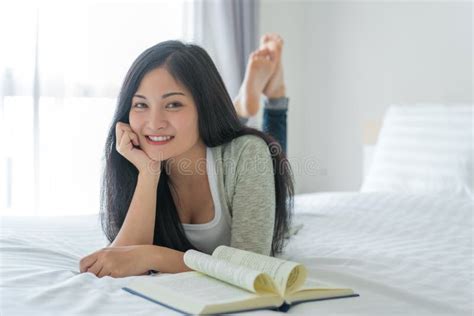 Young Woman Reading a Book on Bed at Home Stock Photo - Image of ...