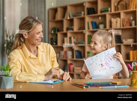 Petite Fille Mignonne Montrant Une Femme Psychologue Son Dessin Enfant