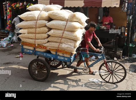 A Coolie Pushes A Bicycle Cart Loaded With Goods Through The George
