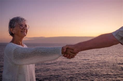 Retrato De Una Anciana Sonriente En La Playa Tocando La Mano De Su