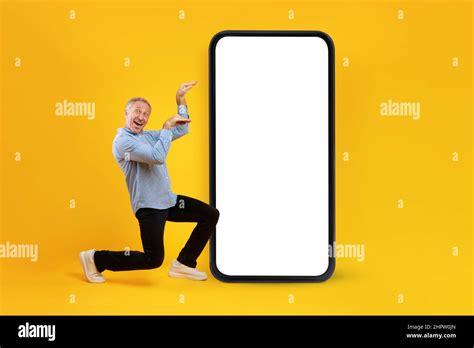 Funny Mature Man Dancing Near Big Cellphone With Empty Screen Over
