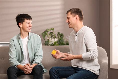 Father Talking With His Teenage Son About Contraception At Home Sex Education Concept Stock