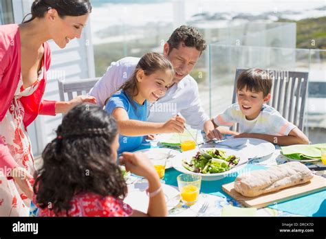 Familia Comiendo En Una Mesa En El Patio Soleado Fotograf A De Stock