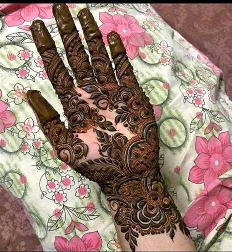 A Woman S Hand Is Decorated With Hennap And Flower Designs On It