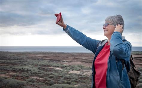 Premium Photo Senior Woman Doing Selfie While Standing Against Sky