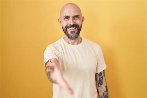 Homme Hispanique Avec Des Tatouages Debout Sur Fond Jaune Souriant