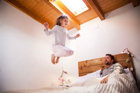 Niña feliz saltando en la cama Foto Gratis