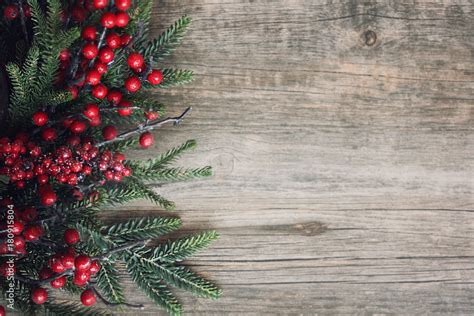 Christmas Evergreen Branches And Berries Over Rustic Wood Background