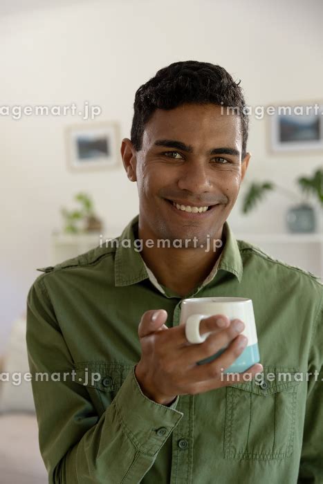 Portrait Of Happy Biracial Man Smiling Holding Mug At Home Lifestyle