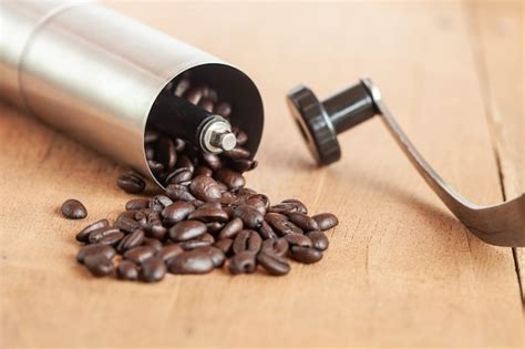 Premium Photo Coffee Bean Spill Out Of Coffee Grinder On Old Wood