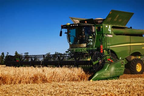 John Deere Harvester Works In The Field Combine Harvesting Wheat