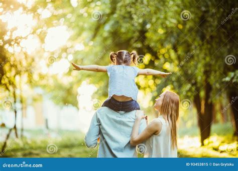 Familia Feliz De Personas Del Tres Que Caminan La Hierba En El Parque