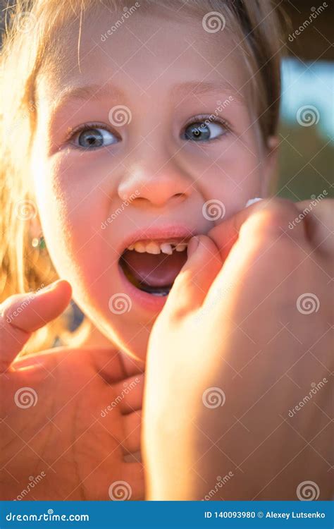 The Process Of Removing A Baby Tooth Using A Thread Stock Photo Image