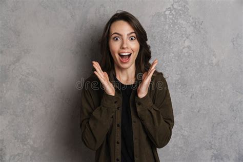 Excited Beautiful Brunette Girl Expressing Surprise At Camera Stock Photo Image Of Wall Grey