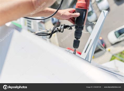 Installing the outdoor unit of the air conditioner, using drill fixing ...