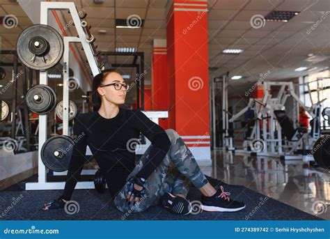 Beautiful Slim Brunette Doing Some Stretching Exercises In A Gym Stock