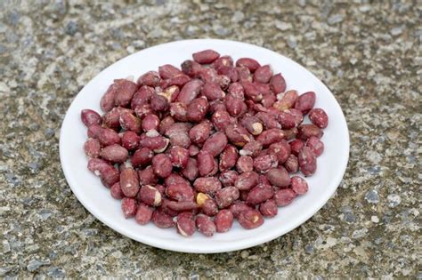 Amendoim Salgado Torrado Em Um Prato Branco Sobre Fundo De Concreto