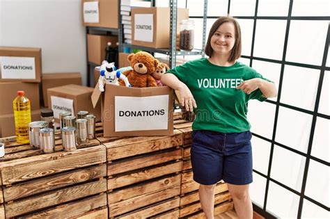 Brunette Woman With Down Syndrome Standing By Box With Donated Toys At