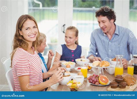 Madre Feliz Que Desayuna Con La Familia En La Tabla Imagen De Archivo