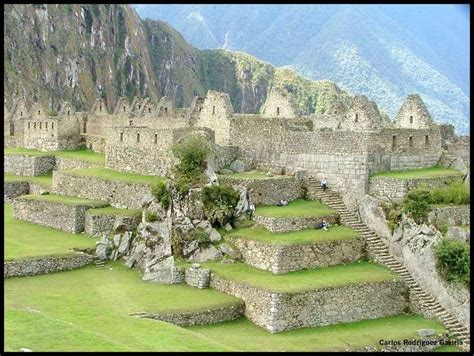 The Ruins At Machaca Picach Are Surrounded By Green Grass And Mountains