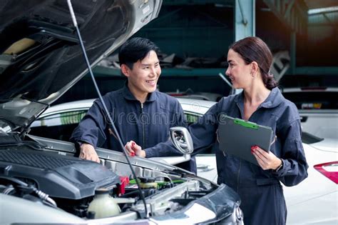 Happy Mechanic Man And Woman Mechanic In Uniform Discussing While