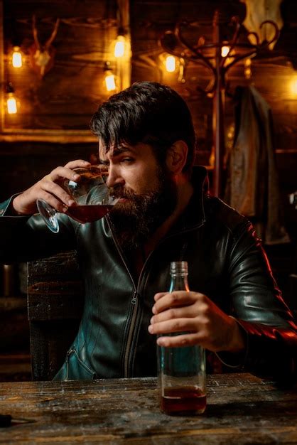 Premium Photo Man With Beard Holds Glass Brandy Macho Drinking