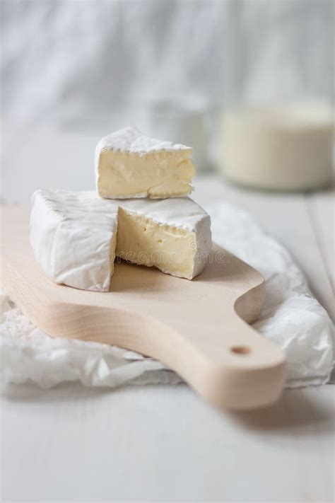 Sliced Fresh Camembert Cheese On The White Wooden Table Selective