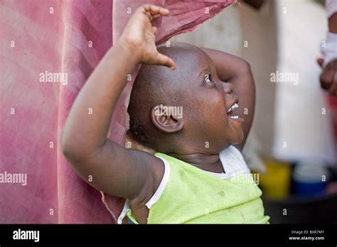 A Young Girl Smiles At Her Mother Despite Living In A Squalid Roadside