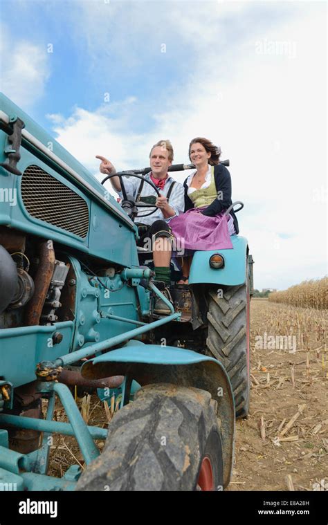 Mature Couple Driving Tractor In Cornfield Bavaria Germany Stock