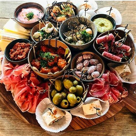 a table topped with lots of different types of food on top of paper ...