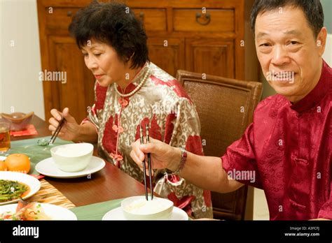 Portrait Of A Senior Man Sitting At A Dining Table With A Mature Woman