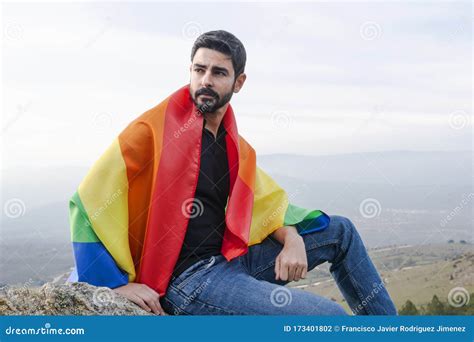 Gay Sentado Con Una Bandera Gay Mirando El Horizonte Foto De Archivo Imagen De Derecho