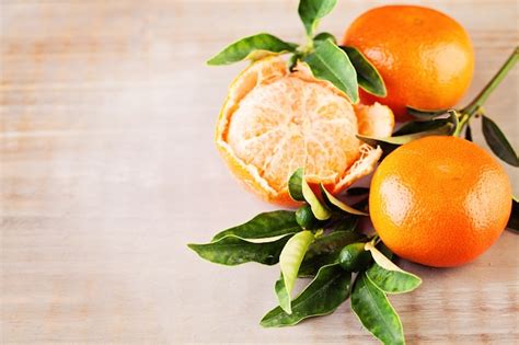 Premium Photo Ripe Mandarin Fruit And Green Leaves On Old Rustic