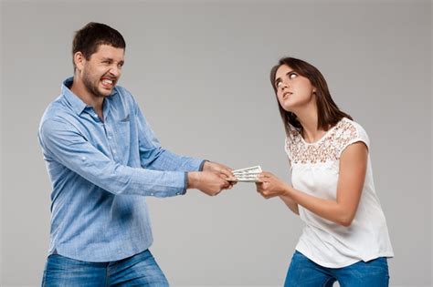 Belle Jeune Femme Prenant De L Argent De L Homme Sur Le Mur Gris