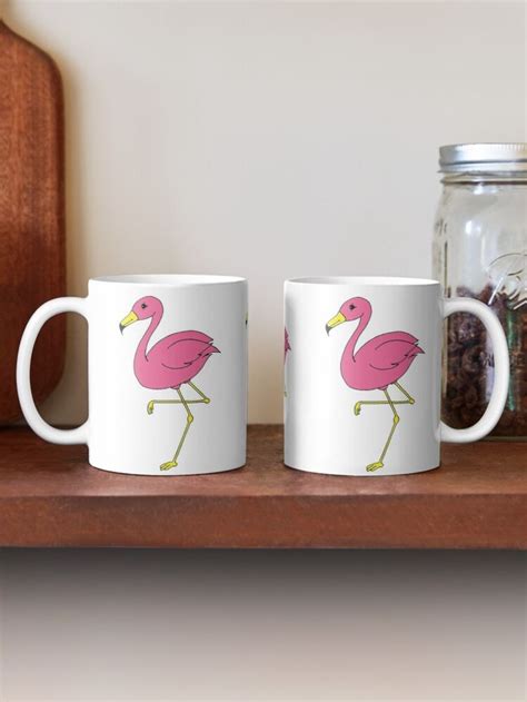 Two Coffee Mugs With Pink Flamingos On Them Sitting On A Shelf Next To