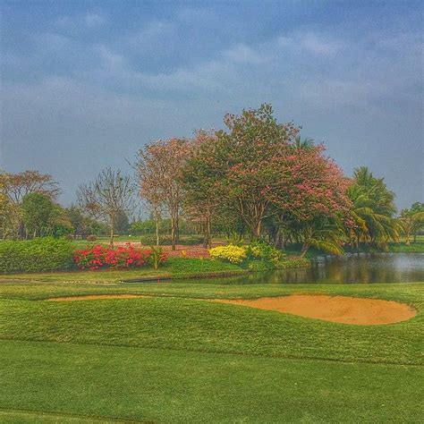 A Golf Course With Water And Trees In The Background