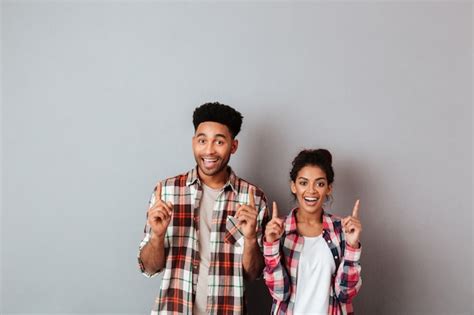 Retrato De Una Alegre Joven Pareja Africana Apuntando Hacia Arriba Con