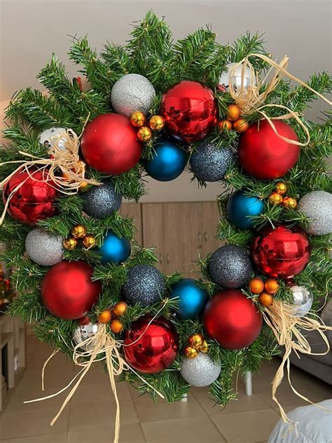 A Christmas Wreath With Red Blue And Silver Ornaments Hanging From It